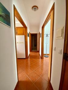 a hallway with a white refrigerator in a house at Casa Do Gerardo in Nazaré +2 photos