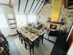 een eetkamer met een tafel en een open haard bij Juniper Star House - Penhas da Saúde,Serra Estrela in Cortes do Meio