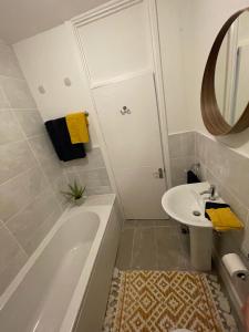 een badkamer met een bad, een wastafel en een spiegel bij 52 Lansdown Crescent in Cheltenham