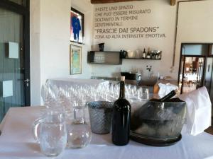 butelka wina na stole z kieliszkami w obiekcie Agriturismo Frascje Dai Spadons w mieście Pradamano