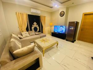 sala de estar con sofá y TV en Holidazzle Serviced Apartments Bahria Town, en Rawalpindi