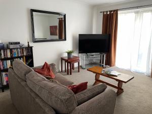 a living room with a couch and a flat screen tv at The Number Eleven Apartment in Kilmuir