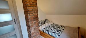 a small room with a brick wall and a bed at Zacisze pod brzozami in Kętrzyn