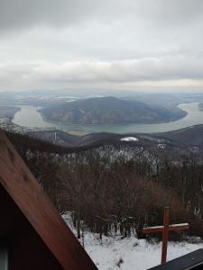 uma cruz no topo de uma montanha com um lago em Vízparti Apartmanház em Leányfalu