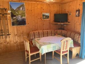ein Esszimmer mit einem Tisch und einem TV in der Unterkunft Ferienhaus Fichtenheim in Prägraten
