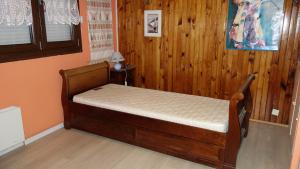 a bedroom with a bed in a room with wooden walls at Les Naïades in Gérardmer