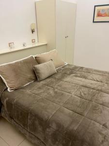 un grande letto in una camera bianca con una grande coperta di Vivalavida Ischia a Ischia