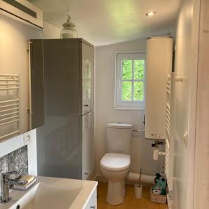 łazienka z toaletą, umywalką i oknem w obiekcie Domaine des Thyllères,Chalet Colvert w mieście Beaufour