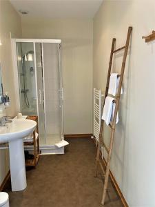 a bathroom with a shower and a sink and a ladder at Le Vauban in Merville-Franceville-Plage