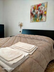 Ce lit se trouve dans une chambre ornée d'une peinture murale. dans l'établissement Appartamento La Ninfea, à Arona