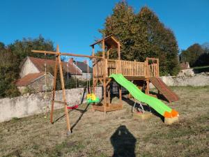 a playground with a slide and a swing at Chez Sivade Gîte in La Crouzille