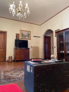 a living room with a table and a chandelier at Dimora tipica toscana in Montecatini Val di Cecina