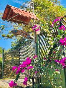 ein Straßenschild mit rosa Blumen vor einem Zaun in der Unterkunft Hospedaje Luis & Ana in Pejibaye
