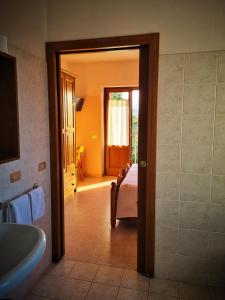a bathroom with a tub and a sink and a bedroom at Hotel Piccola Mantova in Bosco Chiesanuova