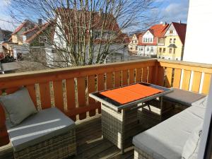 巴倫斯特的住宿－Ballenstedt Schlossblick，阳台配有桌子,甲板上设有长凳