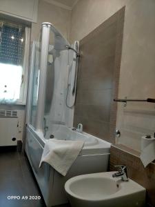uma casa de banho com um lavatório, um chuveiro e um WC. em Appartamento La Ninfea em Arona