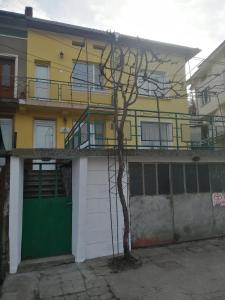 特羅揚的住宿－дом Тодор и Тота Мутевски，一座黄色和白色的建筑,设有绿色车库