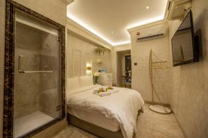 A Residence @ Between Hilton & Cititel Hotel في كوتا كينابالو: غرفة نوم مع سرير وممشى في الدش