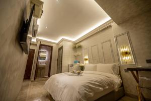 um quarto com uma cama grande e lençóis brancos em A Residence @ Between Hilton & Cititel Hotel em Kota Kinabalu