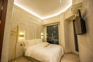 ein Schlafzimmer mit einem weißen Bett und einem Fenster in der Unterkunft ACJ Residence @ Beside Cititel Hotel in Kota Kinabalu