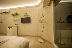 a bedroom with a shower and a television on the wall at ACJ Residence @ Beside Cititel Hotel in Kota Kinabalu