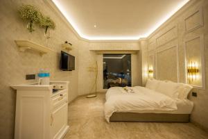 1 dormitorio con 1 cama blanca y TV en ACJ Residence @ Beside Cititel Hotel, en Kota Kinabalu