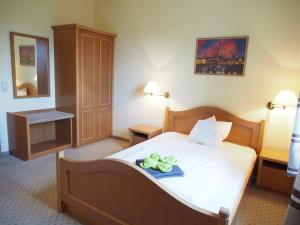 a hotel room with a bed with a towel on it at Altes Teichhaus - Pension Ottendorf-Okrilla in Ottendorf-Okrilla
