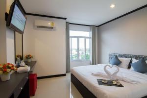 a bedroom with a bed with a tray of food on it at Leelawadee Grand Hotel in Udon Thani