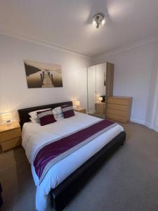 a bedroom with a large bed and two night stands at Apartment 39c in Oban