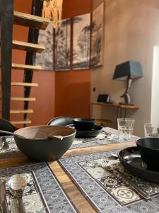 una mesa con tazones y platos encima en LA TOUR YVELINE en Romans-sur-Isère