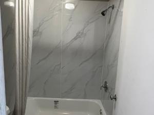 a bathroom with a shower and a white sink at Scottish Inn Augusta downtown in Augusta