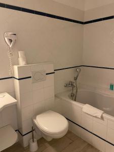 a bathroom with a toilet and a sink and a tub at Au Tapis de Sable in Saint-Cyr-sur-Mer