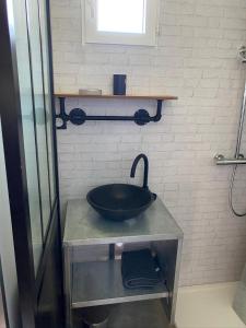 a bathroom with a black sink on a table at Les Apparts in Genneville +7 photos