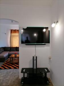 a living room with a flat screen tv on a wall at Khushi's Guest House - Cascavelle in Rivière Noire