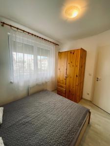 a bedroom with a large bed and a window at Byblos Wellness Apartman Siófok By BLTN in Siófok