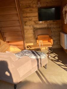 a living room with a couch and a television at Les Apparts in Genneville