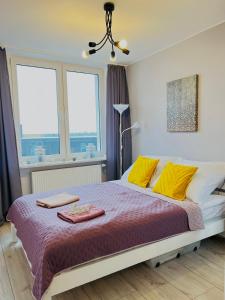 a bedroom with a large bed with yellow pillows at WARSZAWA CENTER POWIŚLE 3 rooms 10th floor view in Warsaw