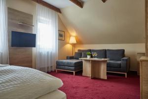 a hotel room with a bed and a couch and a table at Hotel Slunce in Rýmařov