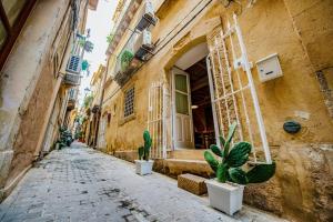 an alley with potted plants in front of a building at Casa Clio in Syracuse