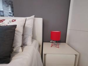 eine rote Kerze auf einem Beistelltisch neben einem Bett in der Unterkunft Apartment Soldo in Zadar