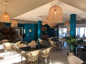 a restaurant with blue walls and tables and chairs at Au Tapis de Sable in Saint-Cyr-sur-Mer