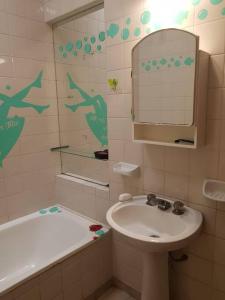 聖米格爾德圖庫曼的住宿－Tu Lugar en Tucumán，浴室配有盥洗盆、镜子和浴缸