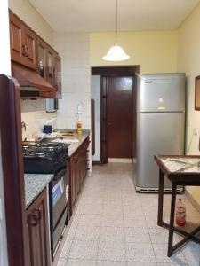 聖米格爾德圖庫曼的住宿－Tu Lugar en Tucumán，厨房配有不锈钢冰箱和桌子