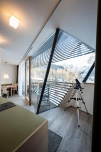 eine Kamera auf einem Stativ in einem Zimmer mit einem großen Fenster in der Unterkunft Residence Königswarte Strata in Sexten