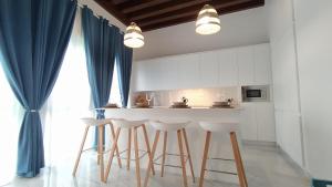 a kitchen with white cabinets and a counter with stools at Sherryflat Teatro in Jerez de la Frontera