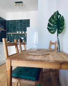 a wooden table with two chairs and a potted plant at Apartament z Widokiem na Morze in Gdańsk