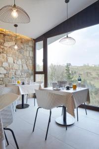 ein Restaurant mit Tischen und Stühlen und einem großen Fenster in der Unterkunft Casa Rural Akei - Basque Stay in Elgóibar