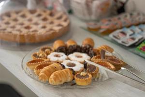 a plate of donuts and other pastries on a table at Capri B&B in Bolzano