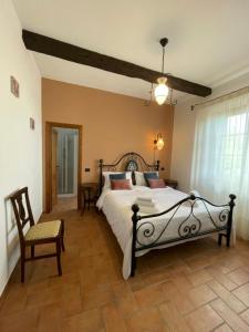 1 dormitorio con 1 cama grande y 1 silla en Agriturismo Il Gonzeto, Montepulciano, en Montepulciano