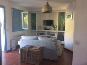 a living room with a white couch and a tv at Molino Cottage in Estepona